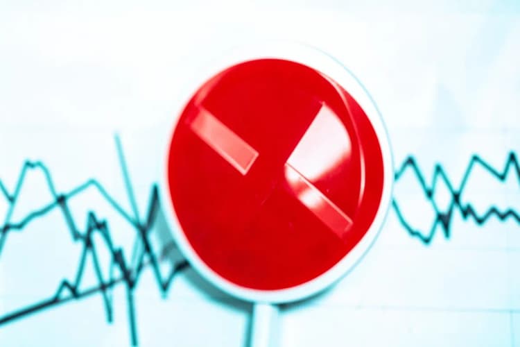 Um sinal de 'proibido' vermelho sobreposto a um gráfico de linhas caótico.