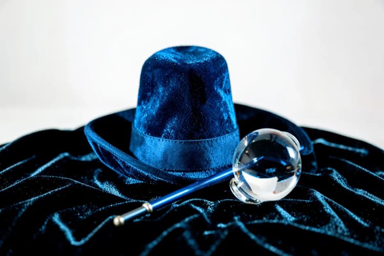 Um chapéu de mágico com uma varinha e uma bola de cristal.