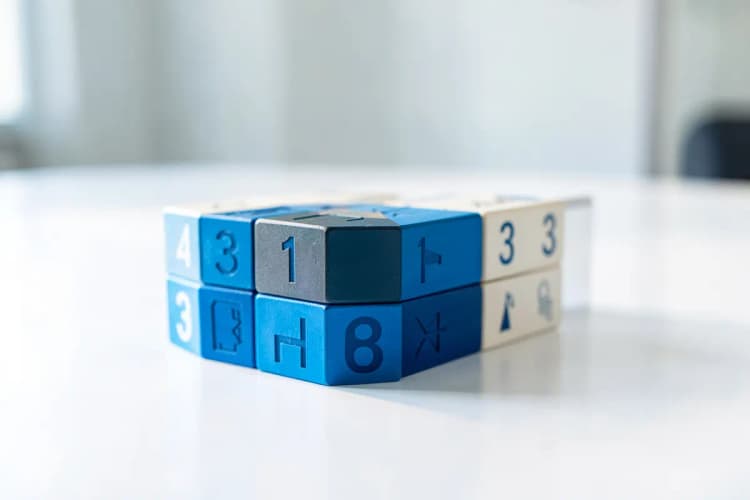 Uma pilha de blocos de madeira com números e símbolos gráficos em cima de uma mesa.