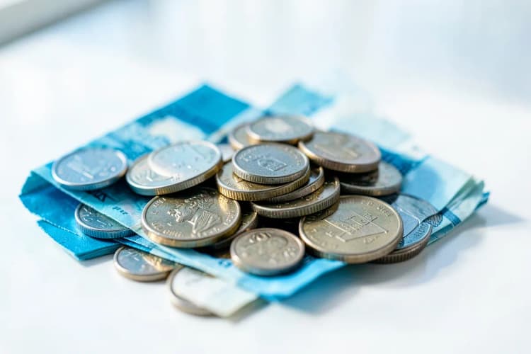 Moedas empilhadas e notas de dinheiro, simbolizando o custo de contratar um profissional.