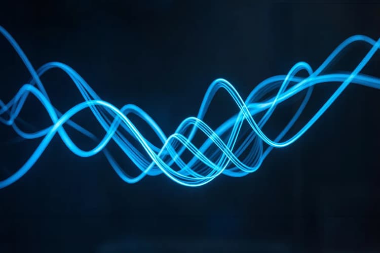 Um gráfico de linha abstrato feito de fios de luz azul brilhante sobre um fundo escuro. A iluminação é gerada pelos próprios fios, criando um efeito etéreo. A imagem é um detalhe, focando na fluidez e no movimento dos fios de luz.