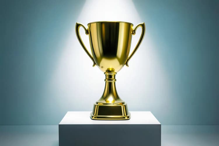 Um troféu dourado brilhante em um pódio com luzes brilhando sobre ele.
