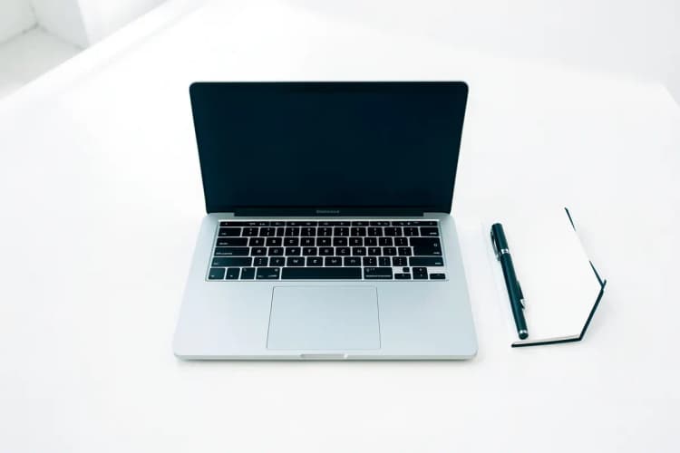 Uma pessoa trabalhando em um laptop em um ambiente de escritório limpo e organizado.