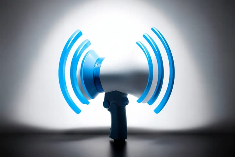 Um megafone emitindo ondas sonoras estilizadas em um fundo azul escuro.